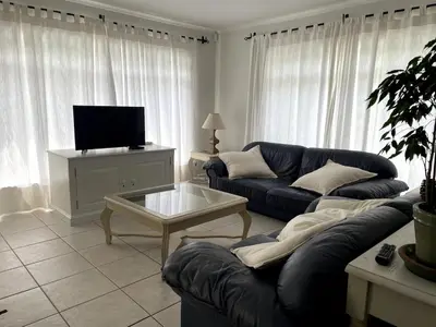 a living room with two couches and a tv at Secret Coastal Garden in Hermanus