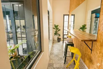 an apartment with a balcony with a bar and yellow chairs at Modern Boho Loft- Observatory in Cape Town
