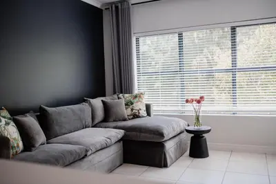 a living room with a couch and a window at Luxury Coastal Escape in Strand in Somerset West
