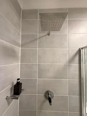 a bathroom with a shower with a shower head at Luxury Coastal Escape in Strand in Somerset West