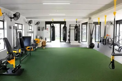 a gym with a green carpeted floor and tread machines at Luxury Coastal Escape in Strand in Somerset West