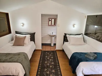 a room with two beds and a sink in it at The Lineage Lodge in Elgin