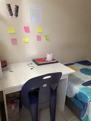 a desk with a chair with a roll of paper on it at The Lavender Residence in Belhar