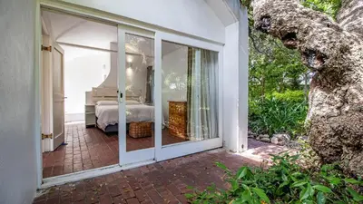 an open glass door to a bedroom with a bed at Birdsong in Hermanus