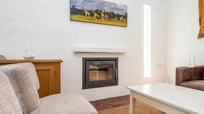 a living room with a fireplace with a picture of giraffes at Birdsong in Hermanus