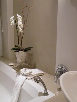 a bathroom with a sink and a vase with flowers at 138 Marine Beachfront Guesthouse in Hermanus