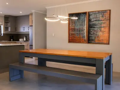 a kitchen with a wooden table in a kitchen at Sandbaai Breeze in Hermanus