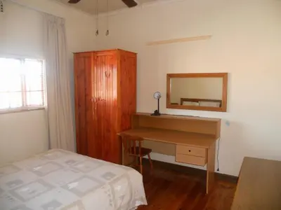a bedroom with a desk and a bed and a mirror at Twin Oaks Lodges in Cape Town