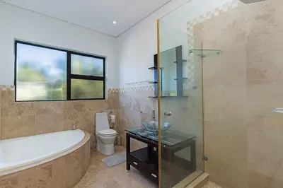 a bathroom with a tub and a sink and a toilet at Sunset Sundowners Villa in Cape Town