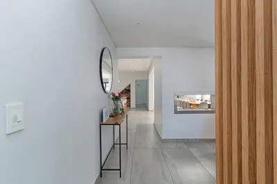 a hallway of a house with a mirror and a table at Sunset Sundowners Villa in Cape Town