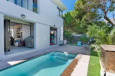 a swimming pool in the backyard of a house at Sunset Sundowners Villa in Cape Town