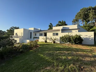 a large white house with a grass yard at Golden Hillside in Somerset West