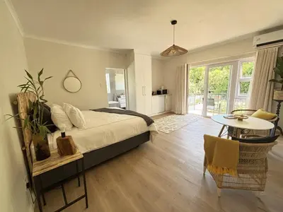 a bedroom with a bed and a table in it at Golden Hillside in Somerset West