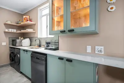 a kitchen with blue cabinets and a dishwasher at Waves and Wildflowers in Cape Town
