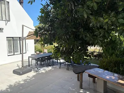 a picnic table and benches next to a tree at Providence in Hermanus