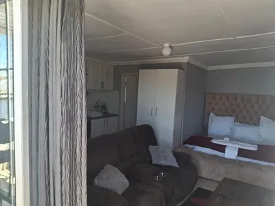 a living room with a couch and a bed at White house apartment in Cape Town