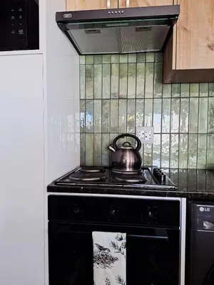 a tea kettle on a stove in a kitchen at Green Olive Luxury Stay - Cozy, modern and central in Tygerberg Hills