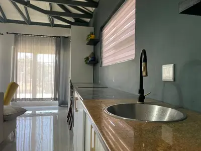 a kitchen counter with a sink and a window at Blouberg kiters in Cape Town