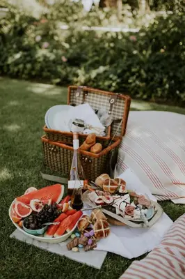 a picnic table with plates of food and a basket of food at Le Grand Jardin Villa in Kayamnandi
