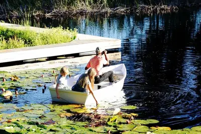 a man and two children in a boat in the water at Le Grand Jardin Villa in Kayamnandi