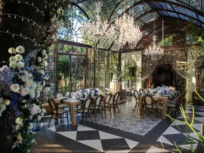 a dining room with tables and chairs in a conservatory at Le Grand Jardin Villa in Kayamnandi