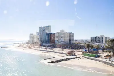 a view of a beach with buildings and the ocean at The Strand Pavillion in Strand