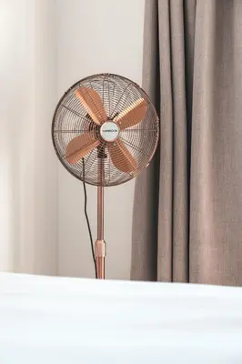a fan sitting on a table in front of a curtain at Abalone at Hermanus Reefs in Hermanus