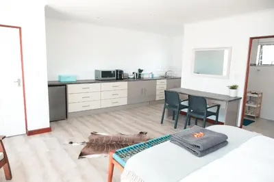 a kitchen with a table and a dog laying on the floor at Abalone at Hermanus Reefs in Hermanus