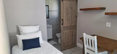 a small bedroom with a bed and a toilet at Family Cottage no 4 in Wellington
