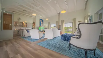 a living room with white chairs and a blue rug at Swallows Rest - Benguela Cove in Hermanus