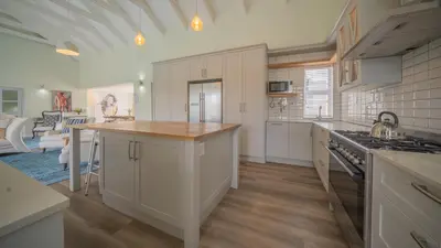 a kitchen with white cabinets and a counter top at Swallows Rest - Benguela Cove in Hermanus