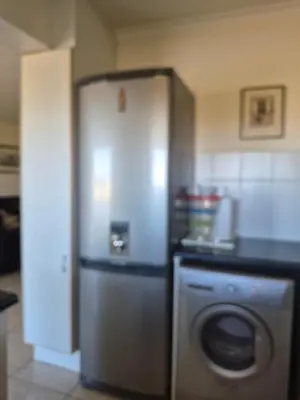 a kitchen with a refrigerator and a washing machine at Apartment in Milnerton, Royal Ascot, Cape Town in Cape Town