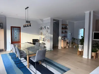 a dining room and living room with a glass table and chairs at Modern & Secure 3-Bed Home with Pool & Garden in Cape Town