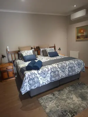 a bedroom with two beds with blue pillows at Spacious Suite in Somerset West in Somerset West