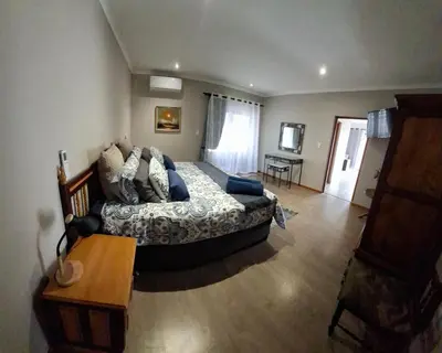a bedroom with a bed and a table in it at Spacious Suite in Somerset West in Somerset West