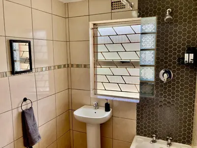 a bathroom with a sink and a mirror at Unit 1 GatherPoint Sleeps 6 Self-Catering Group in Belhar, Cape Town in Belhar
