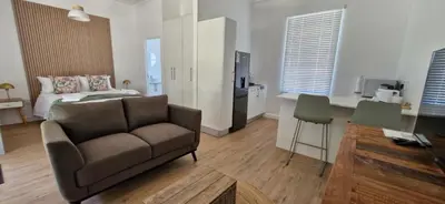 a living room with a couch and a bed at The Barracks at Brigadoon Village in Bettyʼs Bay
