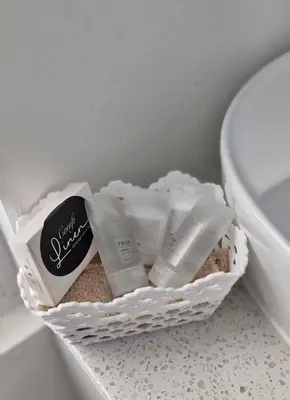 a basket of toiletries sitting next to a toilet at The Barracks at Brigadoon Village in Bettyʼs Bay