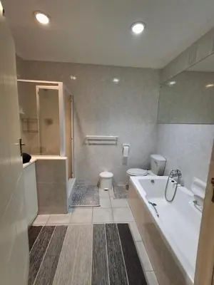 a bathroom with a tub and a toilet and a sink at Spacious Suite Somerset West in Somerset West