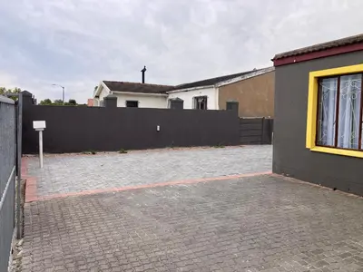 a house with a fence and a brick driveway at Unit 1, TraversHub Sleeps 6 Self-Catering Group Belhar, CT in Belhar