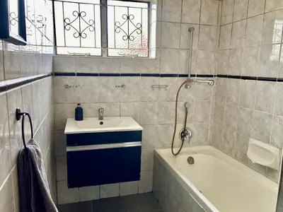 a bathroom with a sink and a bath tub at Unit 1, TraversHub Sleeps 6 Self-Catering Group Belhar, CT in Belhar