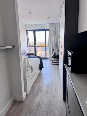 a bedroom with a bed and a large window at Modern Studio at 1 on Albert with Habour View in Cape Town