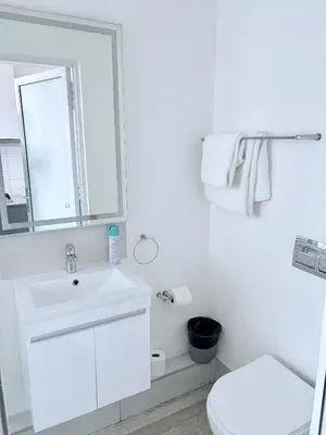 a white bathroom with a sink and a toilet at Modern Studio at 1 on Albert with Habour View in Cape Town