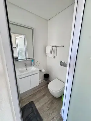 a bathroom with a toilet and a sink and a mirror at Harbour View Modern Studio at One on Albert in Cape Town