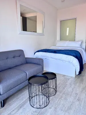 a hotel room with a bed and a couch and a bed at Harbour View Modern Studio at One on Albert in Cape Town