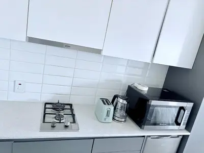 a kitchen counter with a microwave and a stove at Harbour View Modern Studio at One on Albert in Cape Town