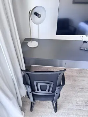 a black chair sitting next to a table with a lamp at Harbour View Modern Studio at One on Albert in Cape Town