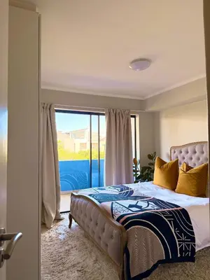 a bedroom with a bed and a sliding glass door at Divine Apartment Century City in Cape Town