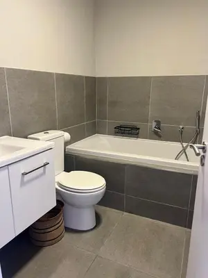 a bathroom with a toilet and a tub and a sink at Divine Apartment Century City in Cape Town