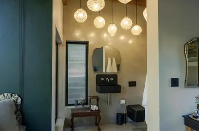 a room with a mirror and lights on the wall at The Little Black Box in Somerset West